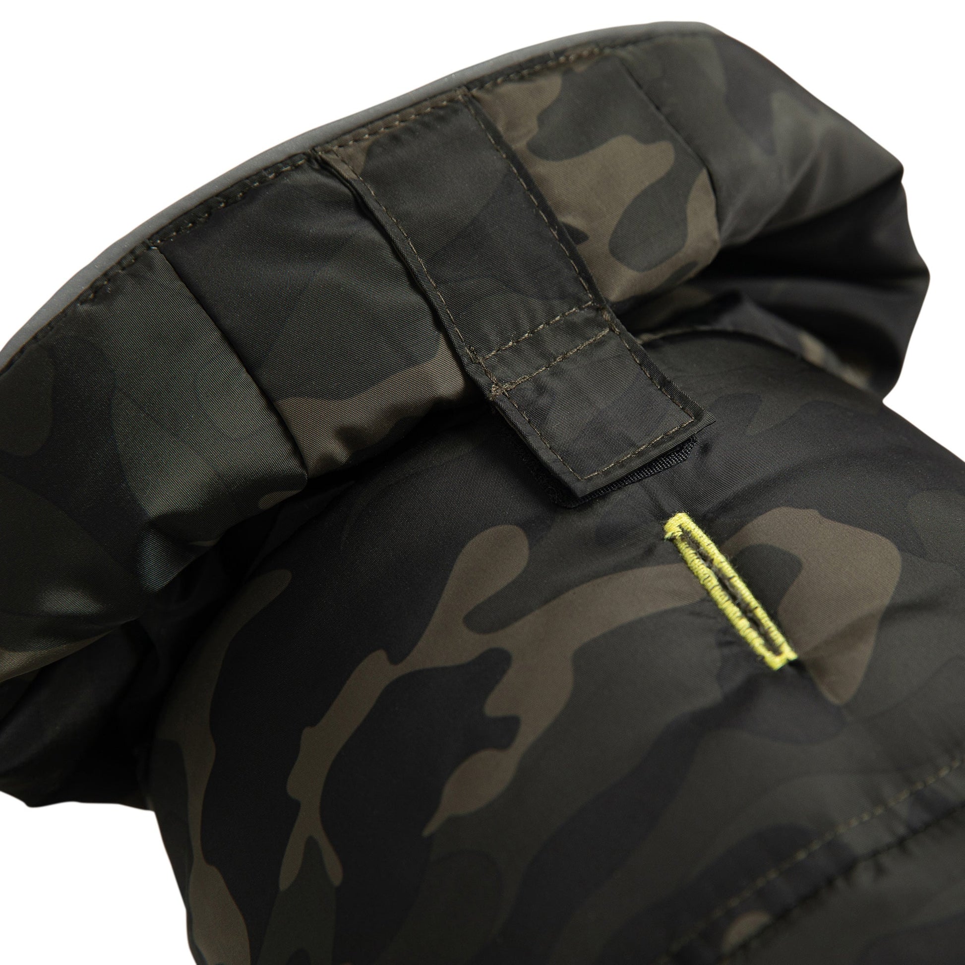 Detail view of GF Pet camouflage recycled parka hood closure showing Velcro fastener and neon yellow accent zipper pull