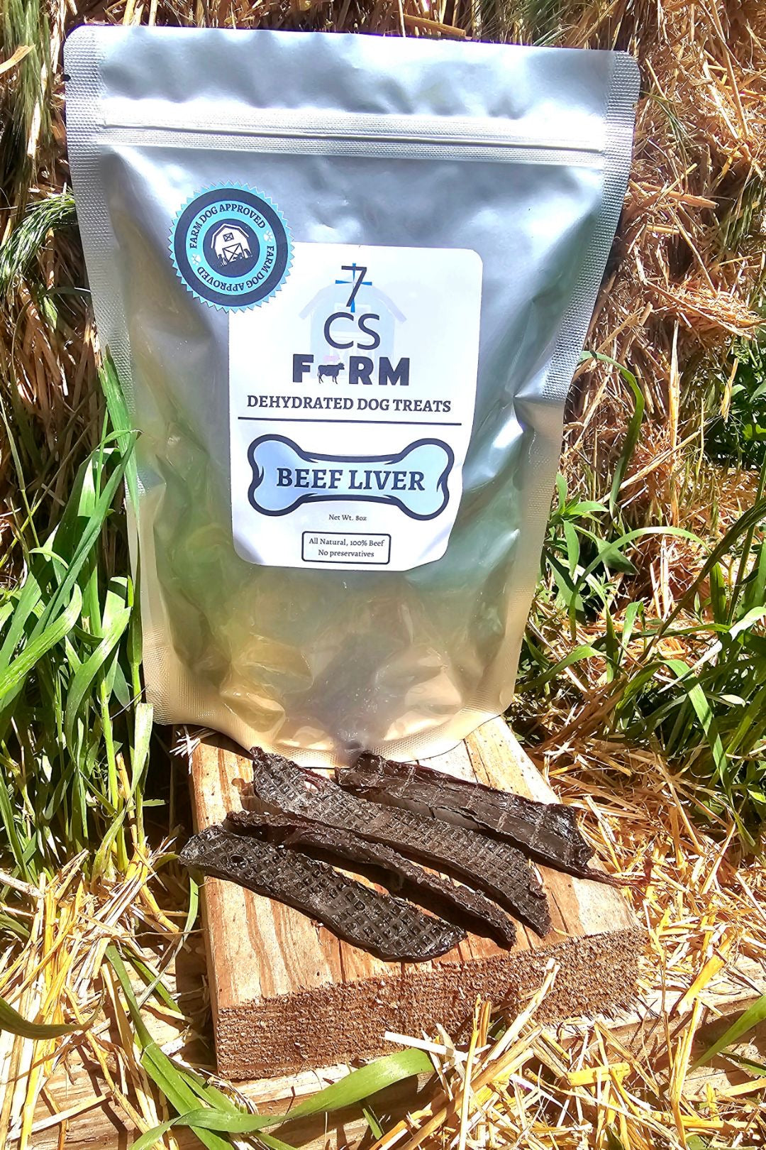 7CS Farm dehydrated beef liver dog treats bag with single-ingredient beef liver strips on hay and wood outdoor setting