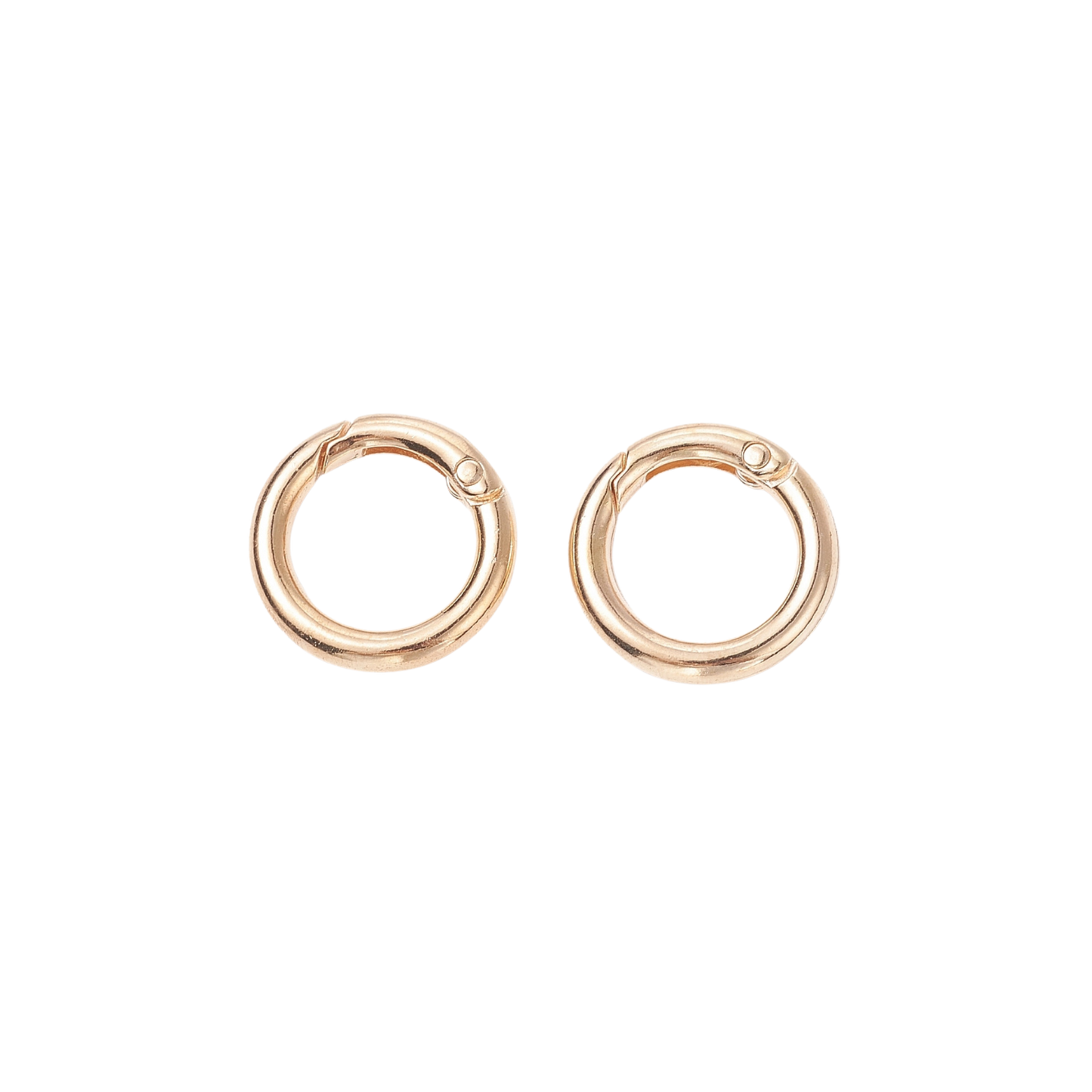 Two rose gold Switch-Bit quick-release dog tag keepers with spring-loaded gates on transparent background