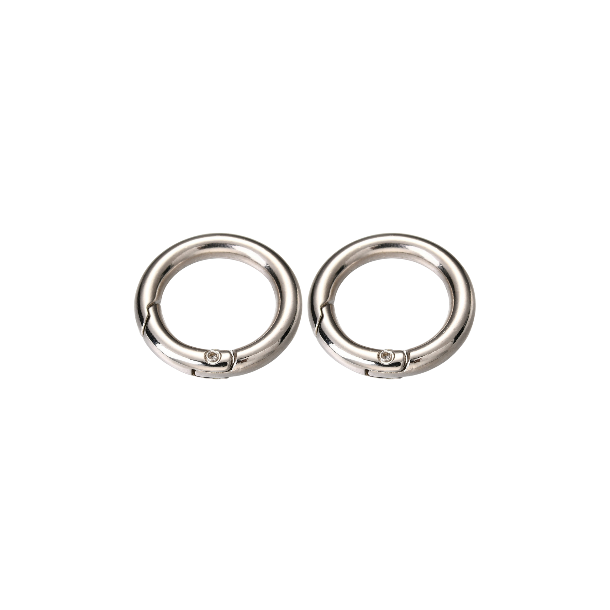 Two silver Switch-Bit quick-release dog tag keepers with spring-loaded gates on transparent background