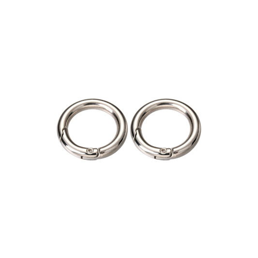 Two silver Switch-Bit quick-release dog tag keepers with spring-loaded gates on transparent background